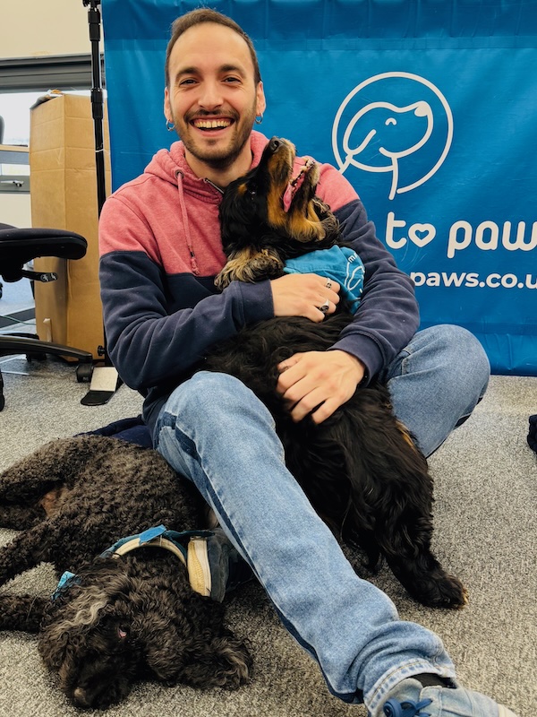Smiling man with therapy dogs in the workplace